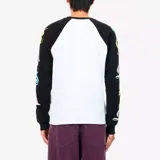 Camiseta de manga larga estilo béisbol, con cuerpo blanco y mangas raglán negras. Presenta un logo gótico negro en el pecho y letras estampadas en colores pastel (rosa, amarillo, celeste) a lo largo de ambas mangas.