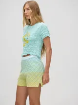 Short de punto tejido con patrón de rombos en tonos degradados de celeste y amarillo. Presenta una pretina elástica y un calce suelto.