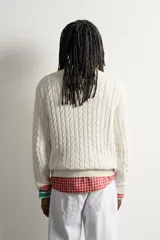 Sweater de punto verde con diseño de trenzas, cuello redondo y manga larga, de corte regular fit y acabados en rib.