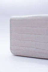 Billetera marrón tipo sobre con cierre de cremallera, confeccionada en cuero con textura tipo cocodrilo y forro textil rojo. Cuenta con múltiples ranuras para tarjetas, documentos y billetes.