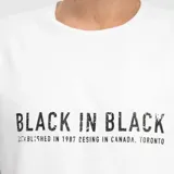 Remera blanca de corte regular con cuello redondo y mangas cortas. Presenta un estampado frontal con la frase 'BLACK IN BLACK' en color negro.