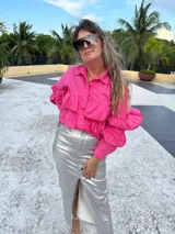 Camisa fucsia de popelina con volados en el frente y mangas largas.