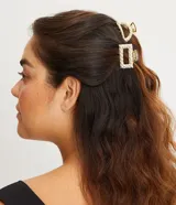 Set de dos pinzas para el pelo doradas con efecto arrugado, una con forma redondeada y otra cuadrada.