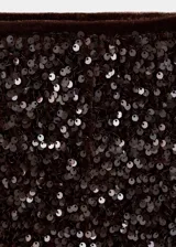 Short corto de tiro alto, confeccionado en terciopelo negro recubierto de lentejuelas brillantes, con cierre de cremallera lateral.