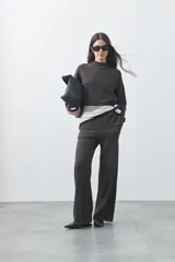 Pantalón de punto de corte relajado, con pierna recta y caída fluida. Presenta cintura con cordón ajustable y diseño minimalista.