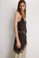 Top lencero de tejido satinado color marrón oscuro, con escote en V y tirantes finos ajustables. El bajo es asimétrico y está adornado con encaje a tono.