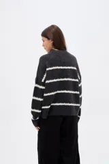 Sweater de punto con diseño de rayas horizontales en contraste, cuello alto y corte holgado con mangas largas.