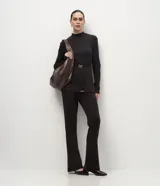Pantalón de corte flare confeccionado en tejido piquet, con cintura alta y ajuste ceñido en caderas y muslos que se ensancha suavemente desde la rodilla.