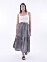 Falda larga gris oscuro de corte evase, con diseño en niveles y cintura elástica con cordón ajustable.