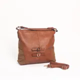 Cartera de hombro color marrón, confeccionada en cuero sintético con paneles laterales de gamuza. Presenta un diseño con dos correas decorativas con hebillas metálicas en el frente, cierre superior y correa larga extraíble y regulable.