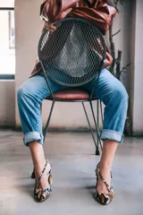 Zapatos de tacón con estampado animal print en tonos marrón, blanco y negro. Tienen punta fina, pulsera con hebilla lateral y tacón ancho. Interior de piel y suela de cuero.