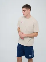 Remera Umbro de manga corta, color celeste, con cuello redondo y el logo de la marca bordado en el pecho.