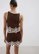 Top Tomi de tejido de punto marrón con diseño sin mangas y cuello redondo, decorado con detalles florales blancos bordados en el borde inferior.