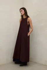 Vestido largo de lino marrón oscuro, sin mangas, con cuello redondo y bolsillos laterales insertados.