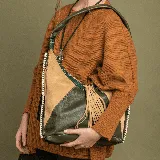 Bolso hobo de cuero vacuno color verde y camel, con correa de cuero y cierre superior. Tiene dos bolsillos verticales con cierre en los laterales, interior forrado con bolsillo con cierre y bolsillo para el móvil.