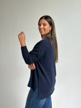 Sweater de punto en color azul marino, con escote en V, manga larga con puños acanalados y costura central vertical en el frente.