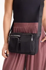 Bandolera negra de nylon con múltiples compartimentos frontales con cierre y correa ajustable.