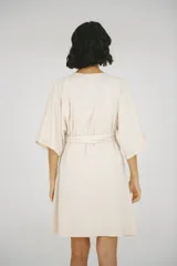 Bata maternal de algodón suave con diseño envolvente, escote en V y lazo ajustable en la cintura. Presenta mangas cortas holgadas y una silueta adaptable ideal para el embarazo y la lactancia.