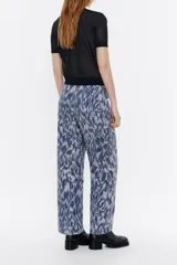 Pantalón de viscosa con estampado animal print, corte recto, largo tobillero, cierre frontal con cremallera de plástico, bolsillos falsos con tapetas laterales y cintura con elástico interior.