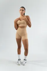 Conjunto deportivo color beige, compuesto por un top con escote redondo y unos shorts ajustados.