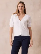 Cárdigan blanco tejido con escote en V, abertura frontal con botones y mangas cortas abullonadas con puño.