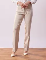 Pantalón de vestir color beige, de corte recto, con bolsillos laterales y traseros. Se ajusta a la cintura con broches internos y cierre.