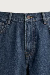 Pantalón jeans de corte regular fit, con pierna recta desde la cadera hasta el tobillo y tiro medio. Confeccionado en denim de algodón rígido con efecto lavado, cuenta con diseño de cinco bolsillos y cierre frontal con botones.