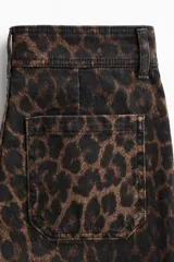 Jean de denim con tiro alto, corte ajustado hasta la rodilla y diseño acampanado, con estampado animal print tipo leopardo. Cuenta con bolsillos de parche delanteros y trabillas para cinturón.
