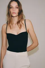 Body lencero color bordó de poliamida, con escote corazón con aro, tirantes finos regulables y cierre inferior a presión.