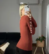 Remera de punto acanalado con escote redondo y cierre frontal parcial con botones. Presenta mangas largas y un ajuste entallado al cuerpo.