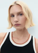 Top de punto fino sin mangas, con cuello redondo y tirantes anchos. Presenta un diseño entallado con detalles de ribetes en contraste en el cuello y las sisas.