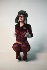 Conjunto de buzo y pantalón de terciopelo rojo con estampado animal print negro. El buzo es de corte ajustado, con capucha y cierre frontal. El pantalón es de corte acampanado y tiene un aplique de estrella de strass en la parte trasera.