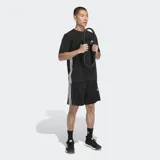 Short deportivo Adidas de corte clásico, color negro con las icónicas tres rayas blancas laterales. Cuenta con cintura elástica, bolsillos laterales con cierre y logo de la marca en la pierna.