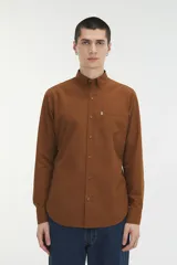 Camisa de manga larga color marrón con estampado de pequeños puntos, cuello abotonado y bolsillo frontal en el pecho.