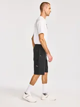 Short cargo color negro con cintura elástica y cordón ajustable. Cuenta con bolsillos laterales, bolsillos traseros y bolsillos utilitarios en las piernas con etiqueta de la marca CAT.