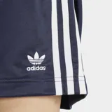 Short Adidas modelo Firebird de corte holgado, color azul marino con las icónicas tres tiras blancas laterales y logo del trébol bordado. Cuenta con cintura elástica y bolsillos laterales con cierre.
