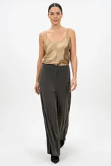 Pantalón tipo palazzo de corte amplio y fluido, confeccionado en tejido con acabado brillante en tono dorado. Presenta cintura elástica para un ajuste cómodo y una caída ligera que estiliza la figura.