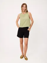 Short negro de gabardina con pinzas delanteras, bolsillos laterales y cierre frontal con botón metálico.