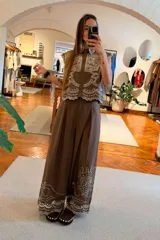 Pantalon de pierna ancha y tiro alto color marron, con bordado en contraste que recorre el ruedo y detalles en calado.