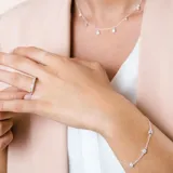 Pulsera de plata 925 fina con dijes redondos de circonias con engarce inglés distribuidos a lo largo de la cadena.