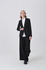 Blazer negro de poliéster, entallado, con cuello solapa y un botón frontal.