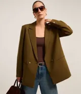 Blazer oversize color verde oliva, con solapas en el cuello y doble abotonadura delantera.