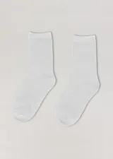Par de medias blancas de media caña, lisas, ideales para uso escolar.