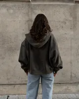 Canguro con capucha color gris oscuro, con cierre frontal y bolsillos tipo canguro.