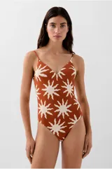 Traje de baño enterizo color terracota con estampado de soles blancos, escote en V, espalda abierta, tirantes regulables y copas removibles.