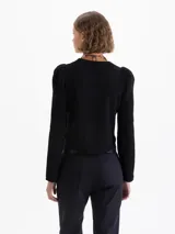 Saco tipo cardigan corto de tejido de punto, con cuello redondo, mangas largas con hombros ligeramente abullonados y cierre frontal cruzado con botones.