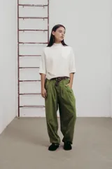 Pantalon de corte amplio y relajado en color verde, con pinzas delanteras, botones decorativos y cinturón de lona incluido.