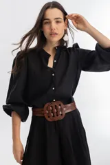 Cinturón de cuero vacuno color marrón con diseño trenzado circular en el frente y cierre elástico en la parte trasera con botones a presión.