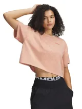 Remera Under Armour de manga corta, corte crop y estilo oversize, en color salmón con efecto lavado. Presenta cuello redondo acanalado y un pequeño parche con el logo de la marca en el pecho.