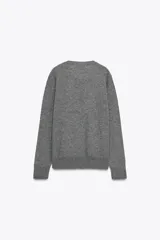 Jersey de punto liso color verde, con cuello redondo y manga larga. Confeccionado en lana suave.